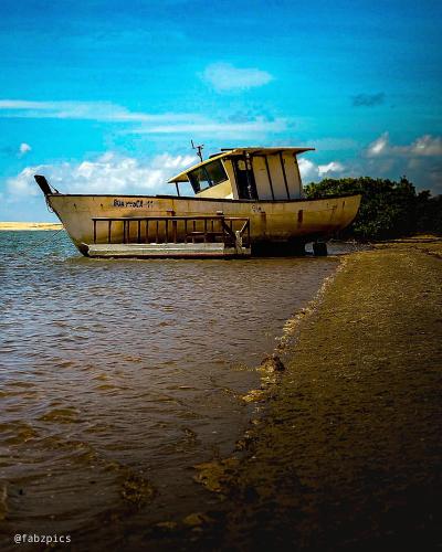 a boat sitting on the shore of a beach at Tree Bies Resort - Oficial in Subaúma