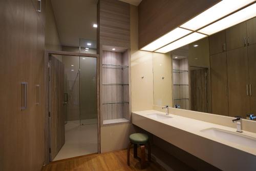 y baño con 2 lavabos, ducha y espejo. en Treescape Resort Chiangmai, en Chiang Mai