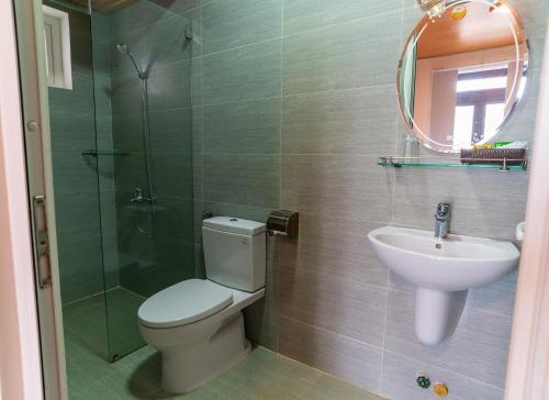 een badkamer met een toilet, een wastafel en een douche bij Villa Đăng Nguyên in Da Lat
