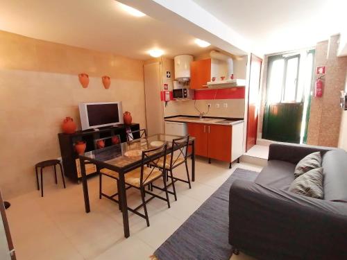a living room with a table and a kitchen at Casa da Avó in Elvas