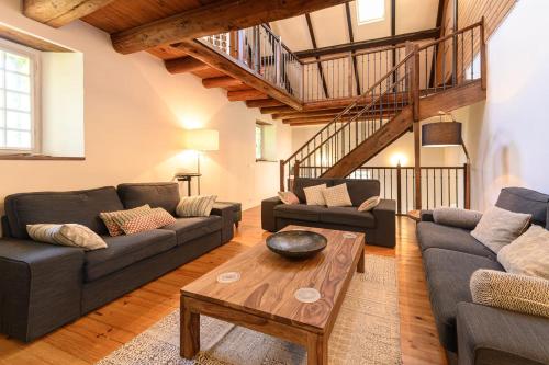 a living room with two couches and a table at Le Moulin de Dingy - House with 6 bedrooms & swimmingpool 20 mn from Annecy in Dingy-Saint-Clair