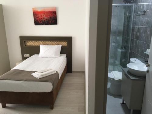 a bedroom with a bed and a bathroom with a shower at Alya Rooms in North Nicosia