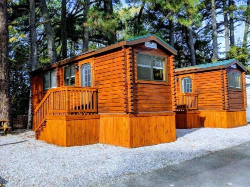 a large wooden cabin with a porch and windows at Anvil Campground in Williamsburg