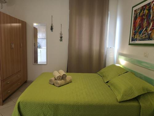 a bedroom with a green bed with towels on it at Ca' Teresa in Santa Maria