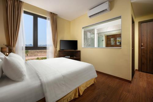 a bedroom with a large white bed and a window at Viryla Boutique Hotel in Vientiane