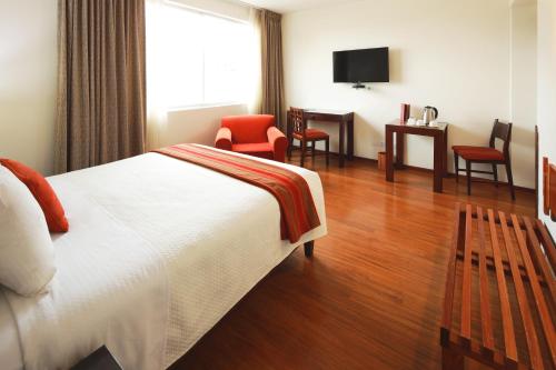 a hotel room with a bed and a table and chairs at San Agustin Exclusive in Lima