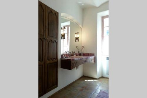 une salle de bain avec un lavabo et un miroir dans l'établissement MAS de la CHICANE, à Blauzac