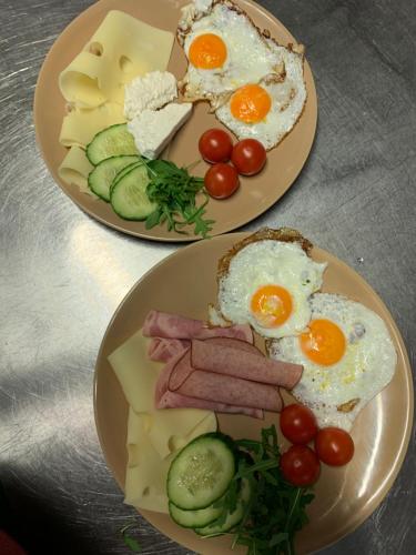 zwei Teller mit Eiern, Schinken und Käse. in der Unterkunft Ristorante Adria in Gloggnitz