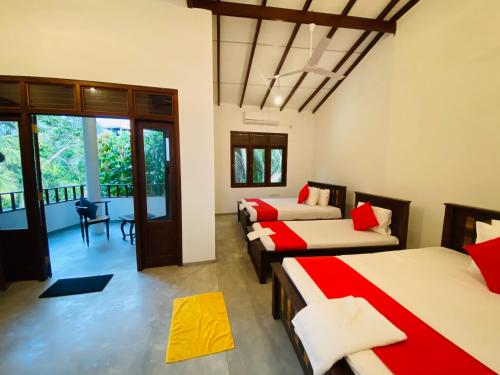 a room with four beds and a balcony at Villa 45 - Balapitiya in Balapitiya