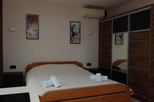 a bedroom with a bed with two towels on it at Apartments Vila Monegro in Bar