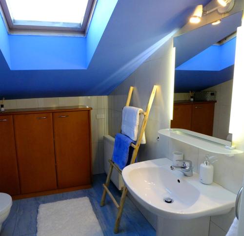 a bathroom with a sink and a blue ceiling at Baker's Pond Loft Apartment in Velden am Wörthersee