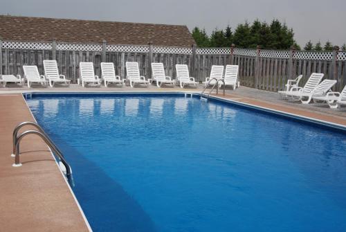 a large swimming pool with chairs at Shining Waters - Ingleside Cottages in Cavendish