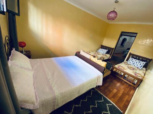 a bedroom with two beds and a mirror at dar leena in Essaouira