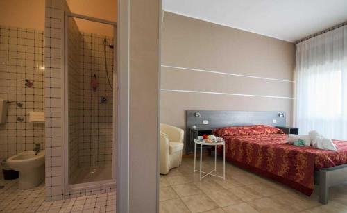 una camera con letto e un bagno con doccia di Hotel Palatinum a Metaponto
