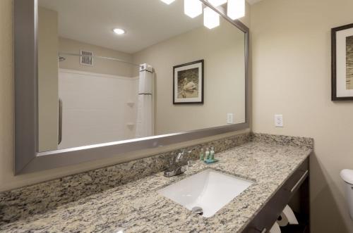 a bathroom with a sink and a large mirror at Grandstay Hotel Milbank in Milbank