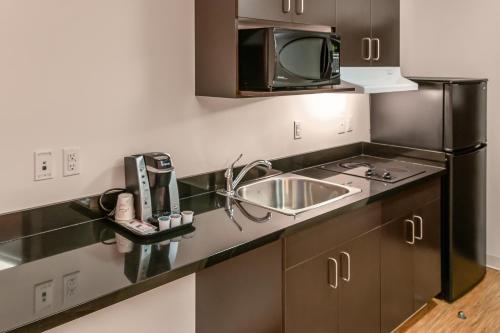 a kitchen with a sink and a microwave at Motel 6-Headingley, MB - Winnipeg West in Winnipeg