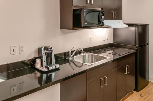 a kitchen with a sink and a microwave at Motel 6-Headingley, MB - Winnipeg West in Winnipeg