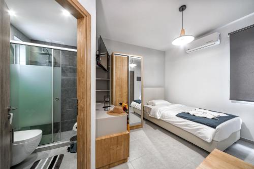 a bedroom with a bed and a bathroom with a shower at Elia Tree Studios in Heraklio