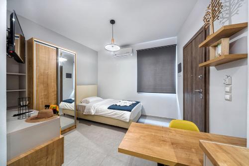 een slaapkamer met een bed, een bureau en een tafel bij Elia Tree Studios in Heraklion