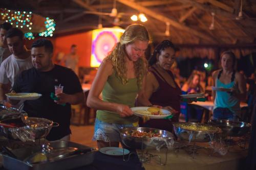 a woman holding a plate of food at a buffet at Lamanai Hotel & Marina in Orange Walk