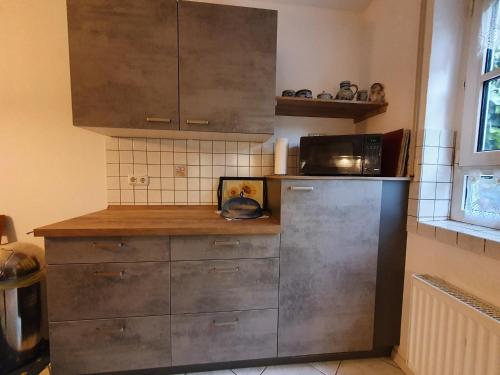 a kitchen with a stainless steel refrigerator and a microwave at Ferienwohnung Wilpert in Schwanfeld