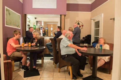 un grupo de personas sentadas en mesas en un restaurante en Ellan Vannin Hotel, en Douglas