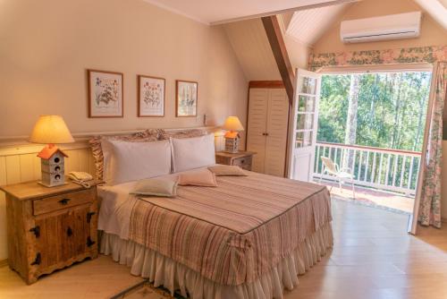une chambre avec un grand lit et un balcon dans l'établissement Recanto Da Paz Hotel Fazenda, à Atibaia