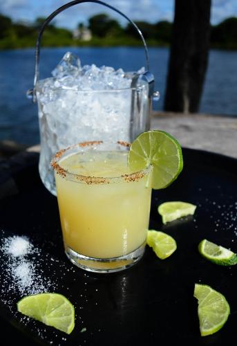 a drink on a black tray with lime slices at Lamanai Hotel & Marina in Orange Walk