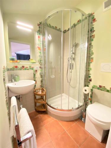 a bathroom with a shower and a toilet and a sink at Appartamenti Sole 1 in Alghero