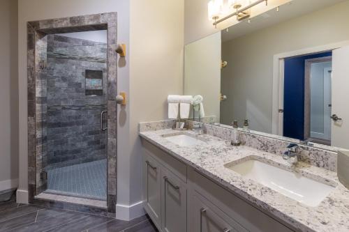 
a bathroom with a sink, mirror and bathtub at The Residences at Biltmore - Asheville in Asheville
