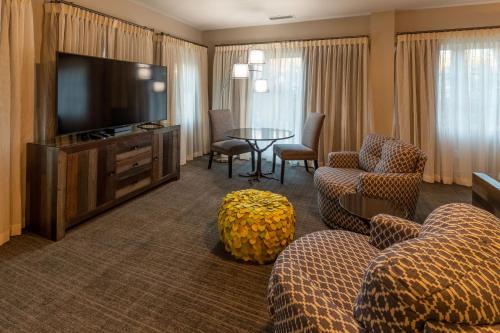 a hotel room with a television and chairs and a table at The Residences at Biltmore - Asheville in Asheville