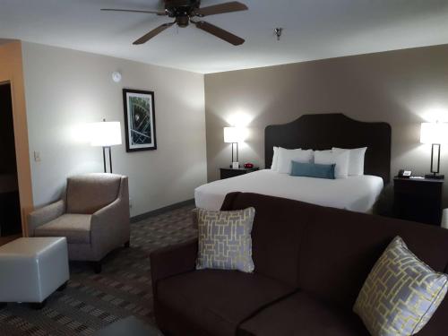 Best Western TimberRidge Inn في Grove: غرفه فندقيه بسرير واريكه