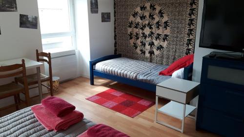 mały pokój z łóżkiem i telewizorem w obiekcie Chez Cathy w mieście Loscouët-sur-Meu