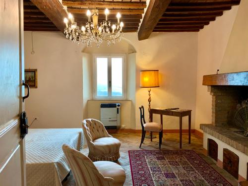 sala de estar con lámpara de araña, mesa y sillas en Casa Cerboneschi, en Casale Marittimo