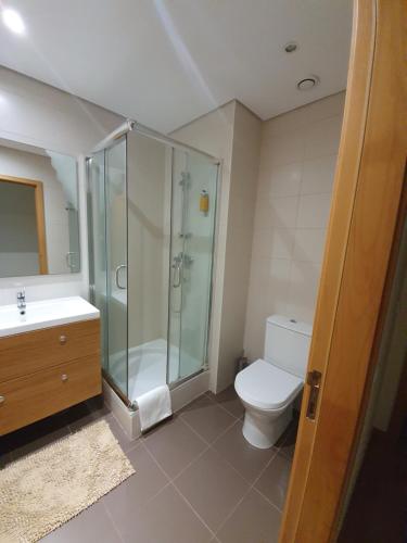 a bathroom with a shower and a toilet and a sink at Apartamento T3 Ponta Delgada in Ponta Delgada