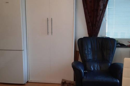 Anvar في دوسلدورف: كرسي ازرق في غرفة مع ثلاجة