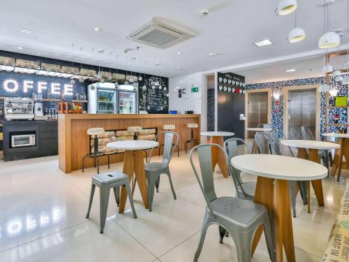 a restaurant with tables and chairs and a counter at ibis Styles Vitoria da Conquista in Vitória da Conquista