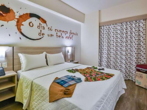 um quarto de hotel com uma cama com flores em ibis Styles Vitoria da Conquista em Vitória da Conquista