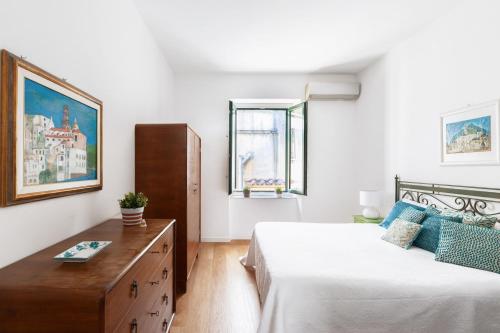 - une chambre avec 2 lits et une commode en bois dans l'établissement Casa Fló, à Salerne