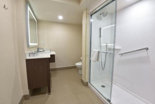 a bathroom with a shower and a sink and a toilet at Victoria Inn Hotel and Convention Center Winnipeg in Winnipeg