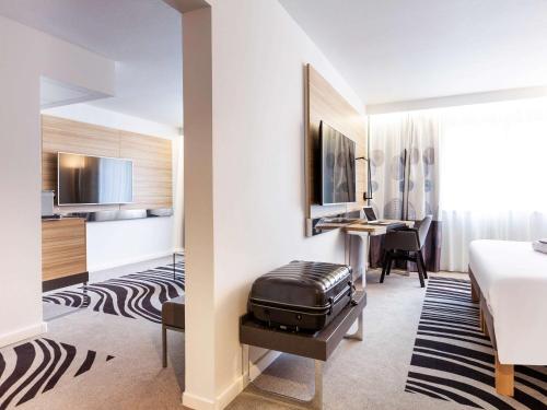 une chambre d'hôtel avec un lit et un bureau dans l'établissement Novotel Limoges Le Lac, à Limoges