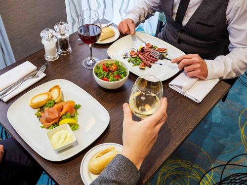 a group of people sitting at a table with plates of food at Novotel Coventry in Coventry