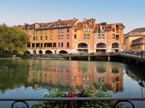 un groupe de bâtiments à côté d'une rivière dans l'établissement ibis Annecy Centre Vieille Ville, à Annecy