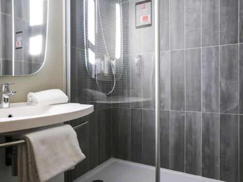 een badkamer met een douche en een wastafel bij ibis Bourg Jasseron/Teyssonge in Jasseron