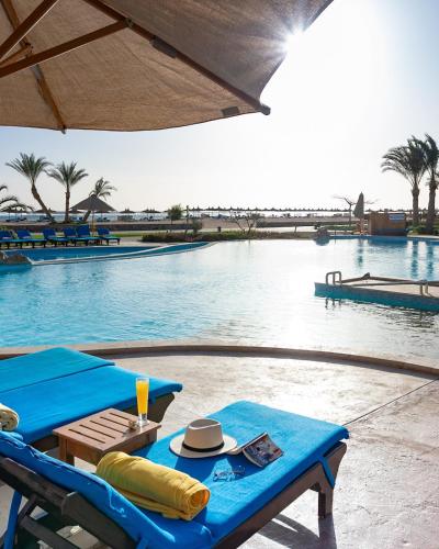 a swimming pool with a table and a hat on it at Novotel Marsa Alam Beach Resort in Quseir