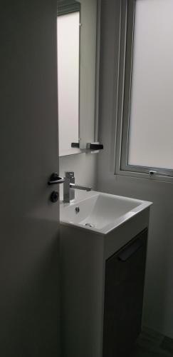 une salle de bain avec un lavabo blanc et un miroir dans l'établissement Camping Val de Boutonne, à Saint-Jean-dʼAngély
