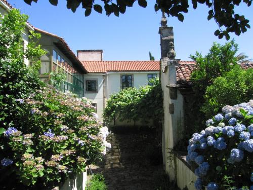 uma casa com um jardim com flores em frente em Pazo Cibrán em San Xulián de Sales