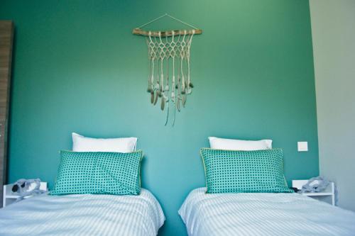 - 2 lits dans une chambre avec un mur bleu dans l'établissement Maison d'Hôtes L'Etiquette, à Seyssel