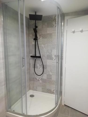 une douche avec une cabine en verre dans une salle de bain dans l'établissement Le Mas du Bijou Bleu, à Puget-sur Argens