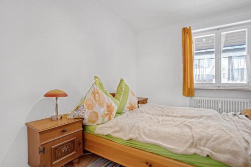 a bedroom with a bed and a nightstand and a window at Haus Marianne in Bischofswiesen